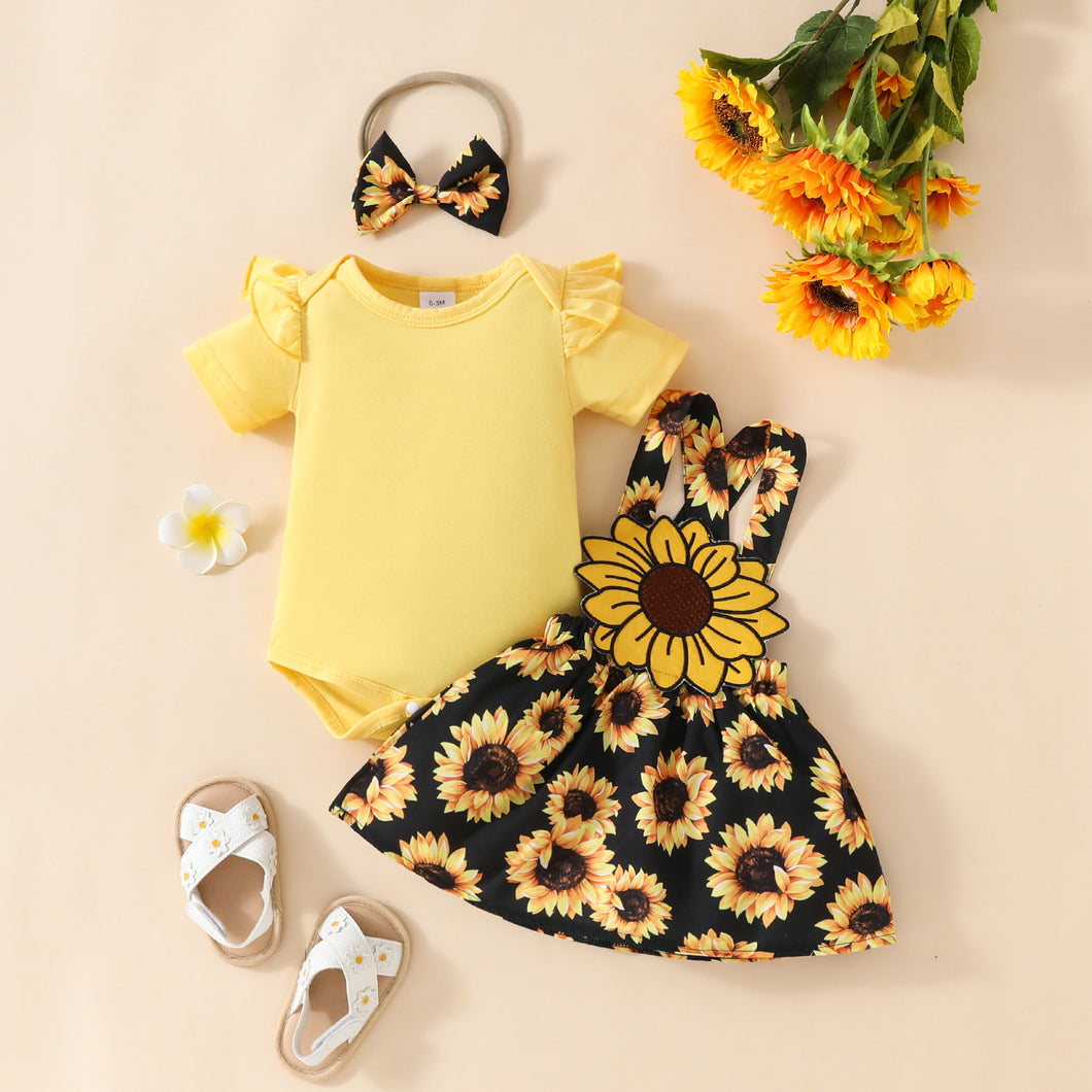 Body amarillo acanalado y vestido tipo jardinera de girasoles negro con vincha